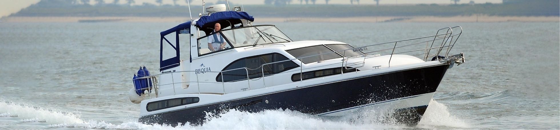 front angle shot of a Zooming blooming broom boat sailing through